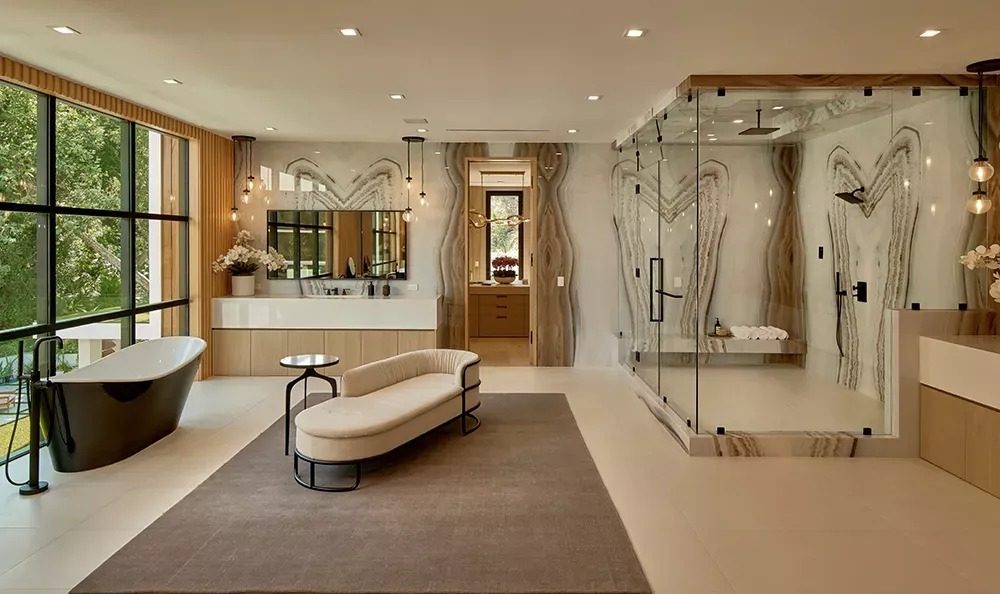 Master bathroom with book-matched stone and glass shower